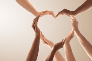 Group of hands forming the shape of a heart